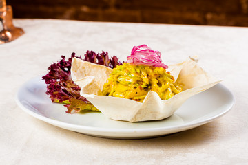 Mixed shredded vegetables with sauce in flat bread basket