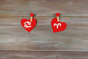 Cancer and Aries. signs of the zodiac and heart. wooden backgrou