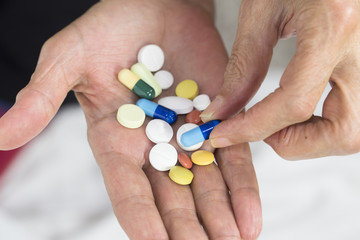 Senior woman holding assorted capsules in her hands. Conceptual of health care for the elderly.