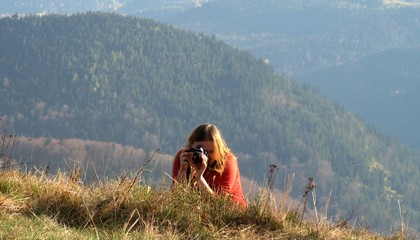 Girl with a camera on a meadow