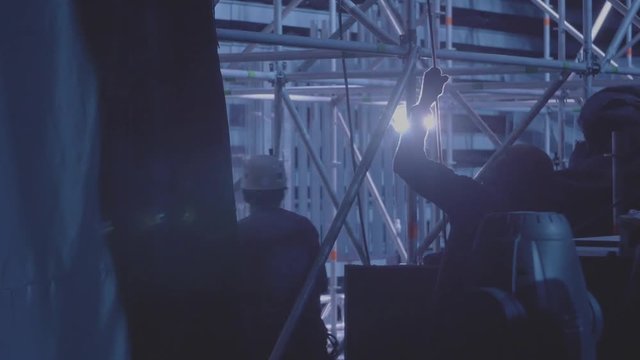 Technical preparation for the big concert indoors. Workers prepare the stage for the concert