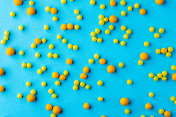 Many yellow pills on blue background