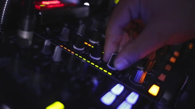 Dj hands playing and mixing music in a nightclub