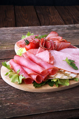 Food tray with delicious salami, pieces of sliced ham, sausage, tomatoes, salad and vegetable - Meat platter with selection