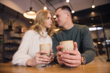 A couple is sitting in the cafe and celebrating Valentine's day. They are on a date. The atmosphere of love in the air.