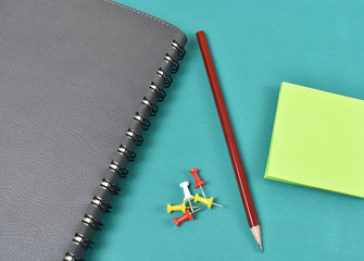 Notepad, pencil, paperclips against the background of a green table