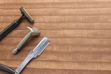 Shaving razor, safety razor and straight razor on a wooden textured background