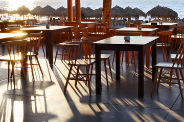 The restaurant on the beach in the shade of the low sun at sunset