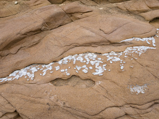 Crystalline layer emerges due to sandstone erosion.