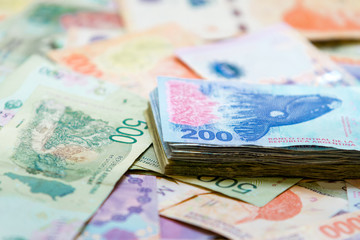 Macro close-up of 200 Argentine pesos bills stacked on top of others of different values