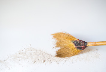 Broom sweeping powder on white floor.