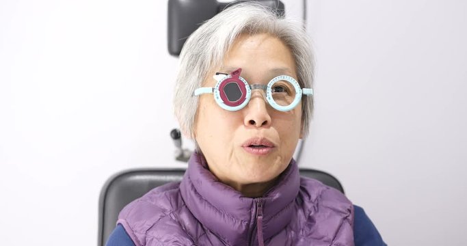 Asian senior woman doing eye sight test