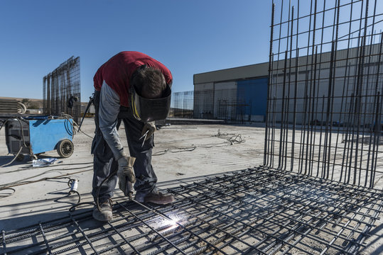 Man makes rebar welds on internal structures that will go inside the cement