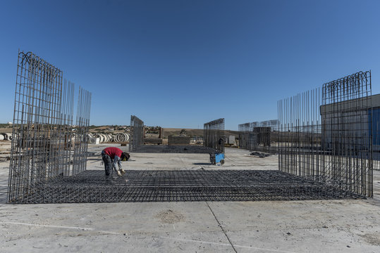 Man makes rebar welds on internal structures that will go inside the cement