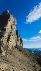 Female hiker below a massive mountain wall