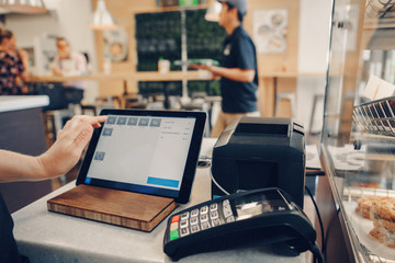 Closeup shot of caucasian cashier hands. Seller using touch pad for accepting client customer payment. Small business of coffee shop cafeteria. - 188972359