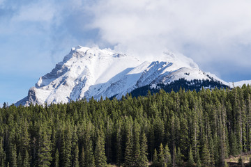 Obraz premium Beautiful snow covered mountain, peak hidden by cloud