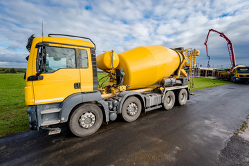 Wohnungsbau - gelber Betonmischer auf einer Baustelle