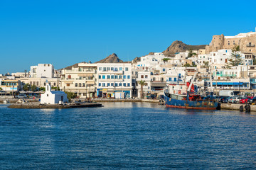 Fototapeta na wymiar White houses of Naxos (Chora) town in port on Naxos island. Greece