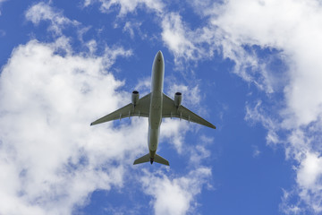 Fototapeta na wymiar Airplane flies against a background of white cloud