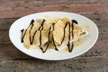 Serving pancakes on the plate. With chocolate syrup.On a wooden background. Top view. rustic food