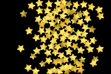 Golden confetti isolated on black background.