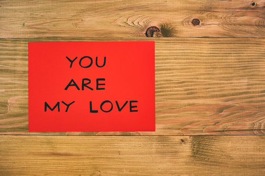 Message you are my love on red paper  on wooden table.