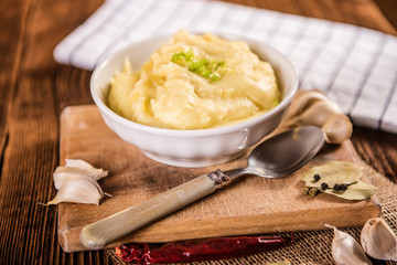 mash potatos in a white porcelain bowl on wood table 