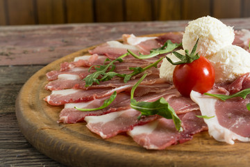 Sliced ham on wooden background. Fresh prosciutto. Pork ham sliced.On a wooden background. rustic food