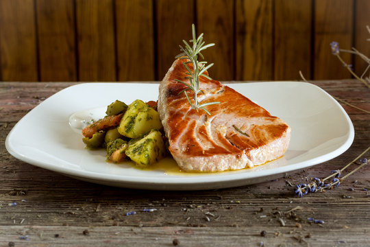 Tuna Steak with Fried Potatoes. On a wooden background. rustic food