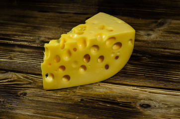 Piece of cheese on wooden table