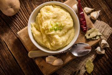 mash potatos in a white porcelain bowl on wood table 