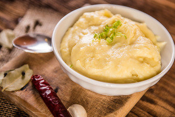 mash potatos in a white porcelain bowl on wood table 