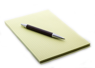 The pen lies on a notepad, next to the button
