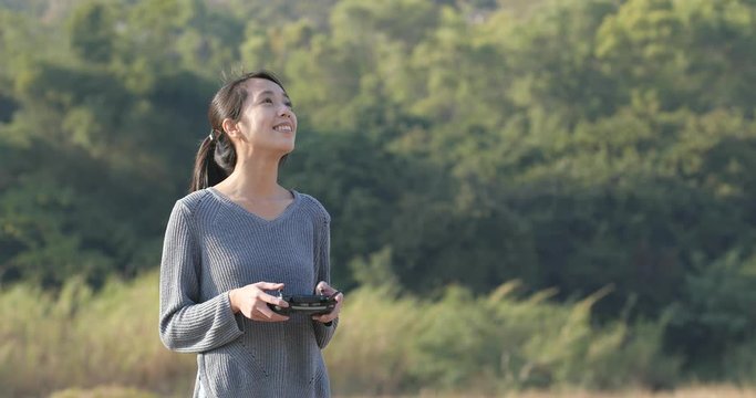 Woman control flying drone at outdoor