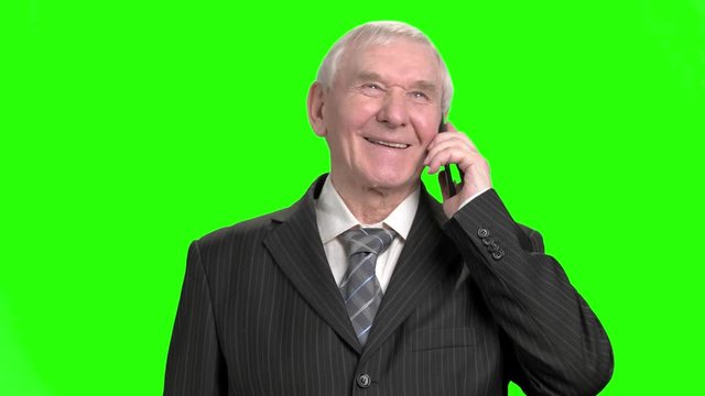 Senior businessman talking on phone and laughing. Granddad in suit talking on phone and laughing out loud.