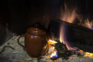 Traditional cooking style of the south of Spain. Pot boiling straight to the embers next to the firewood.