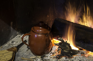 Traditional cooking style of the south of Spain. Pot boiling straight to the embers next to the firewood.