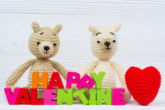 Sweet couple teddy bear doll in love with valentine text and red knitting heart on white wooden background and copy space for add text and picture, love and valentine day concept.