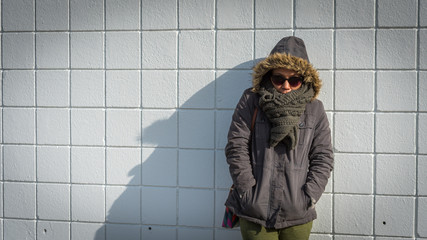 Woman standing in front of White tile wall © David