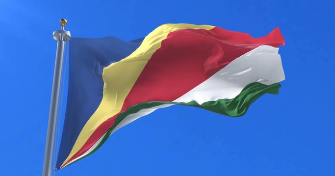 Seychelles flag waving at wind in slow in blue sky, loop