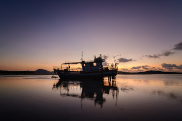 Obraz premium Fisherman boat in a beautiful view on the sea at sunrise