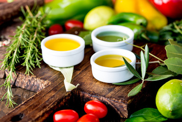 Oils, spices ahd herbs selection. Grape, olive and corn oils fresh herbs, lemons peppers. CSelective focus