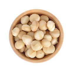 Macadamia nut in wooden bowl isolated on white background