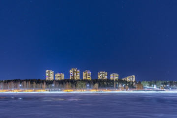 Kronans juldekorerade höghus glittrar ikapp med den vackra och stjärnklara vinterhimlen i Luleå © Roland