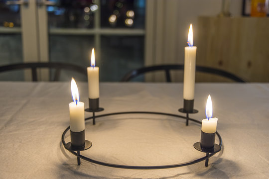 Rund julljusstake lyser med sina fyra t&auml;nda ljus p&aring; julbordet