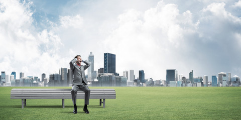 Young man in suit in park dont want to hear anything