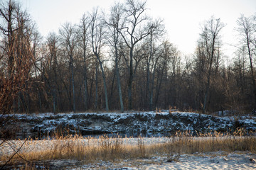 First snow in autumn river coast