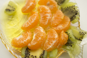 Jelly dessert with fruit. Slices of tangerine and kiwi.