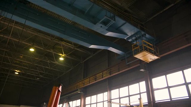 Heavy bridge crane moving alongside the factory